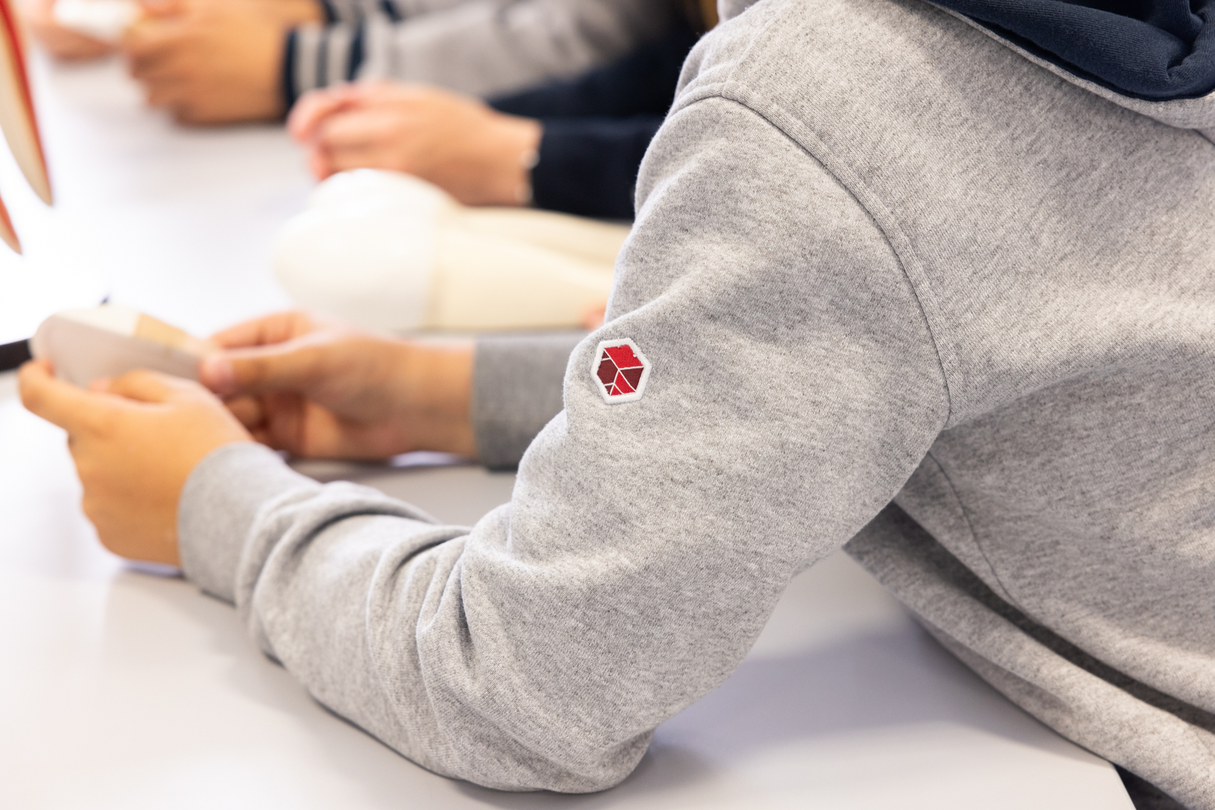 Ein Schüler trägt ein Sweatshirt mit Phorms Logo auf dem Ärmel im Phorms Gymnasium Hamburg