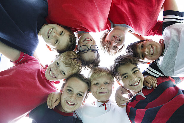 Acht Schüler stehen im Kreis und gucken runter auf eine Kamera im Phorms Gymnasium Hamburg