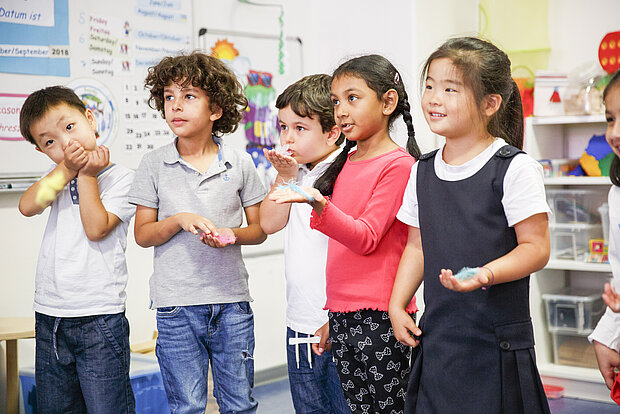 Kinder der Phorms Kita Hamburg stehen im Kreis während einer Kitaaktivität