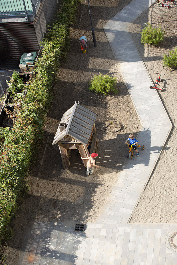 Der Schulhof der Phorms Kita in Hamburg mit Klettergerüst und Kindern