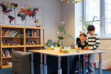 Phorms Hamburg Grundschule Kinder spielen gemeinsam Gesellschaftsspiel Zwei Kinder sitzen gemeinsam an einem Tisch und spielen ein Spiel